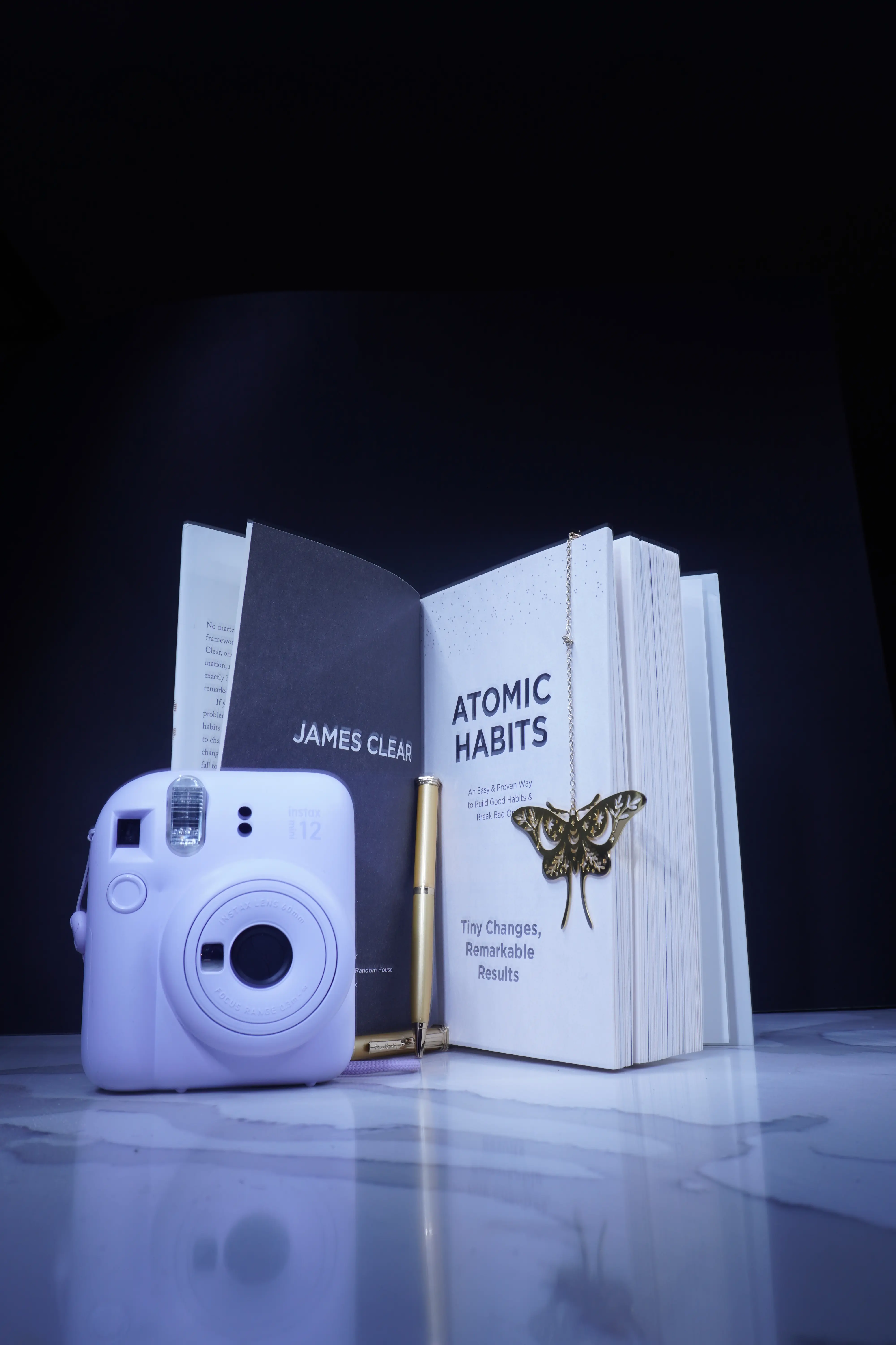 Still life photography of Atomic Habits book and camera